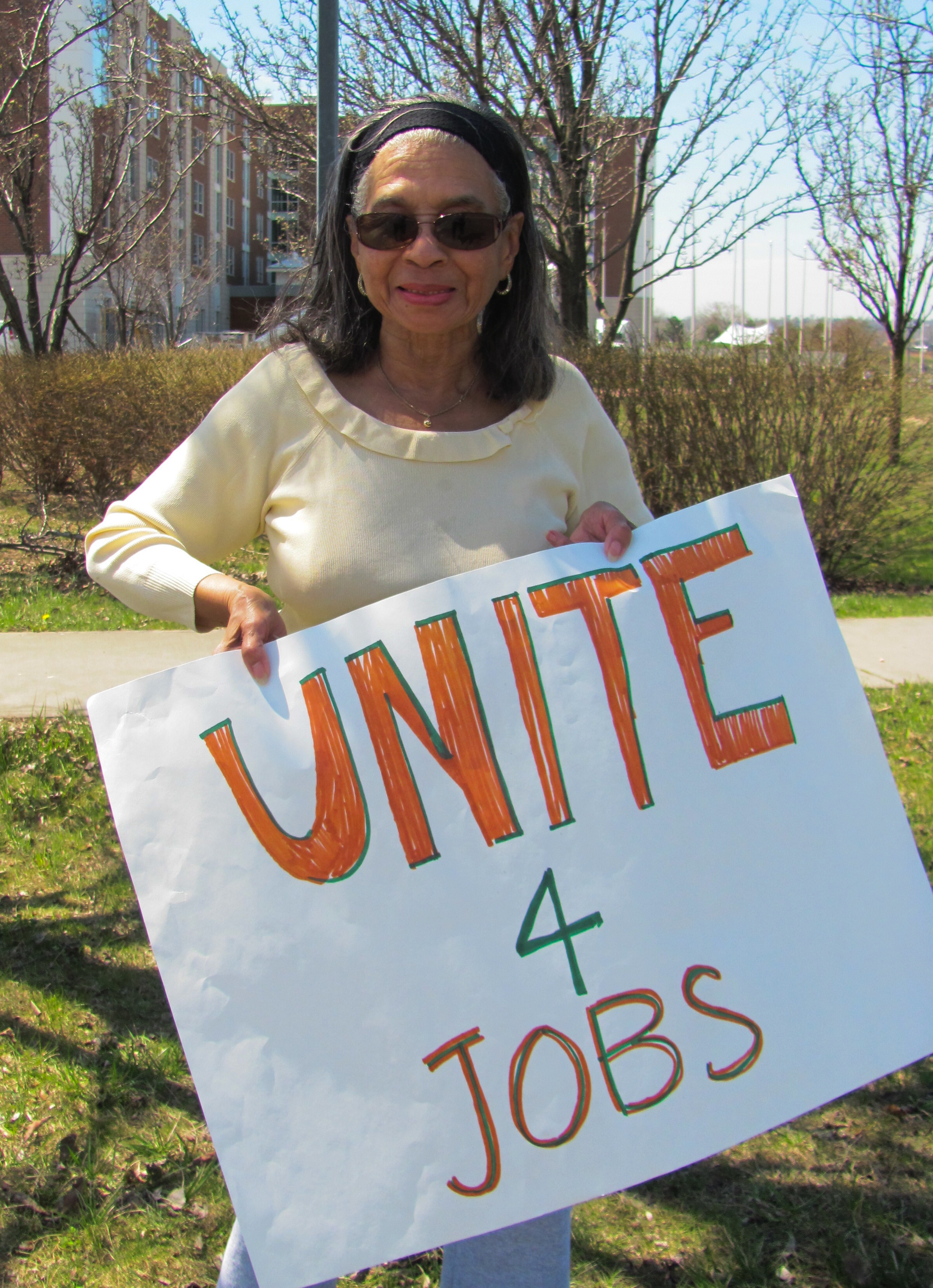 Aggie Lane holding sign that reads, "Unite for Jobs"