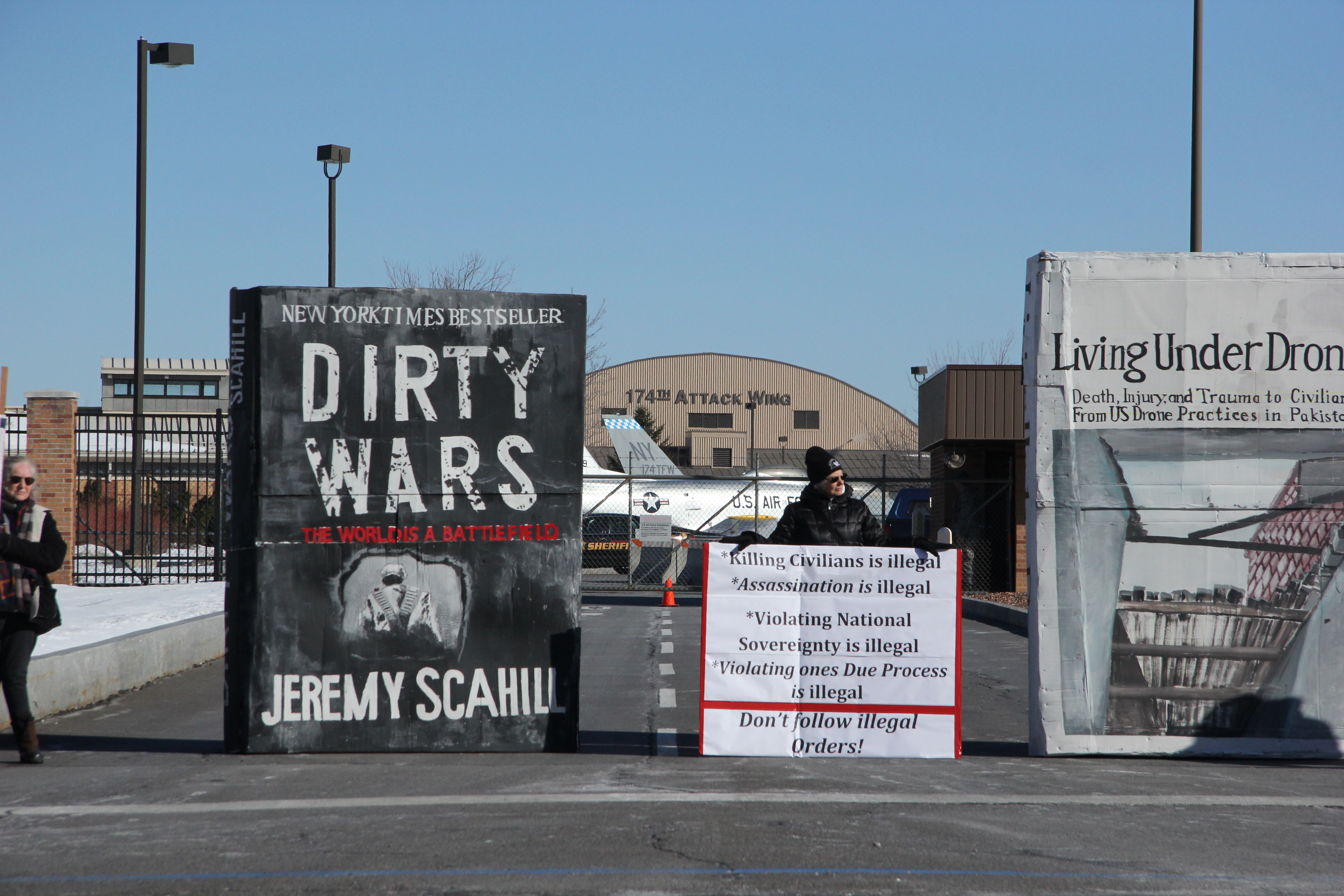 Large anti-war and anti-drone books standing in a parking lot foran anti-drone p